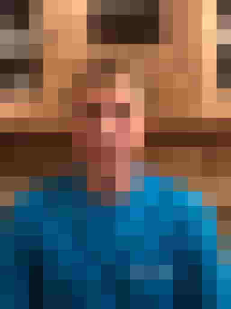 Mitarbeiter von Holzbau Gläser in blauer Arbeitskleidung vor Holzregalen.