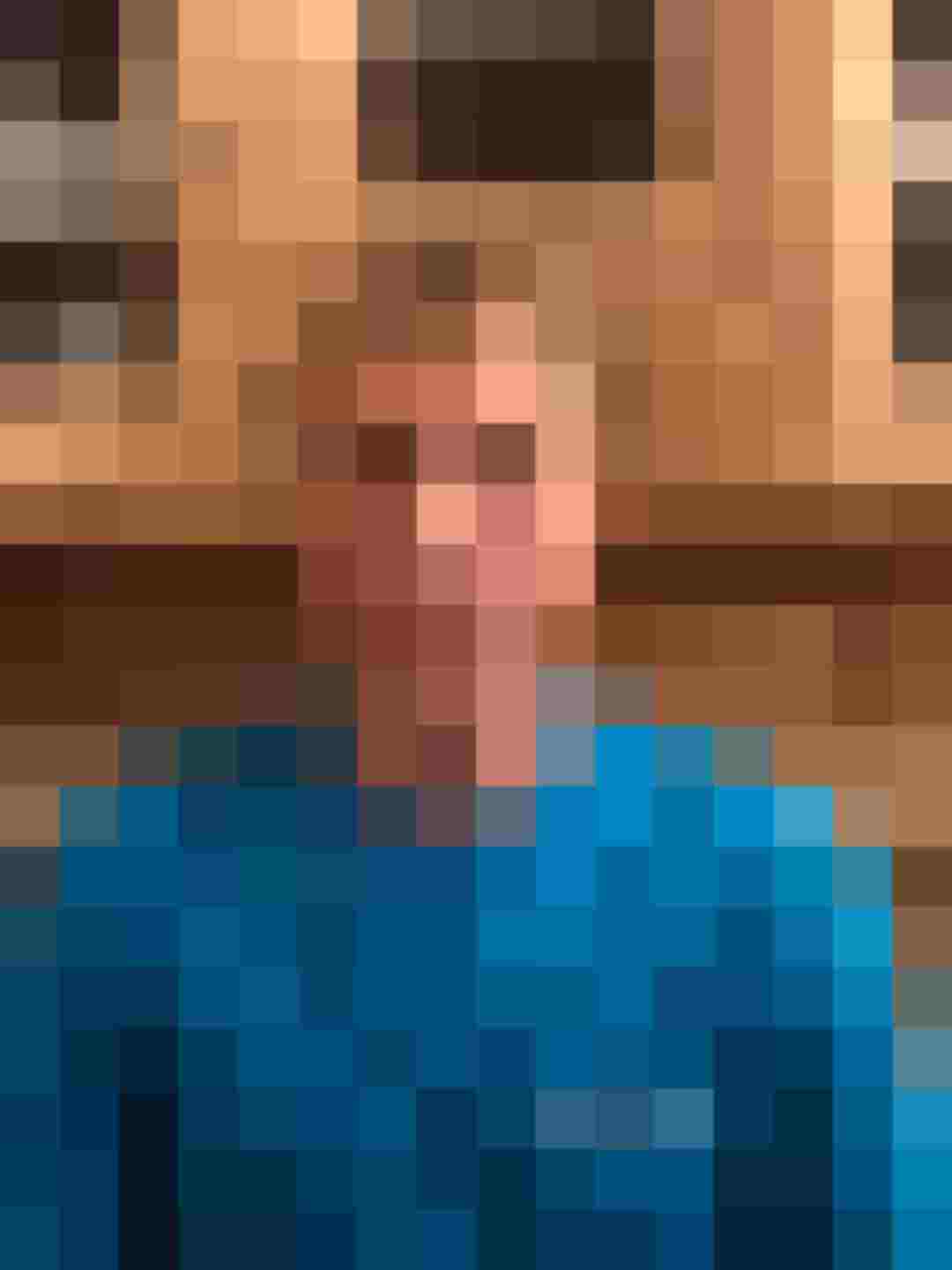 Mitarbeiter von Holzbau Gläser in blauer Arbeitskleidung vor Holzregalen.