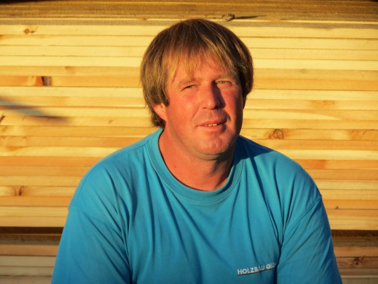 Thomas Gläser von Holzbau Gläser vor einer Holzstruktur in Piesendorf.